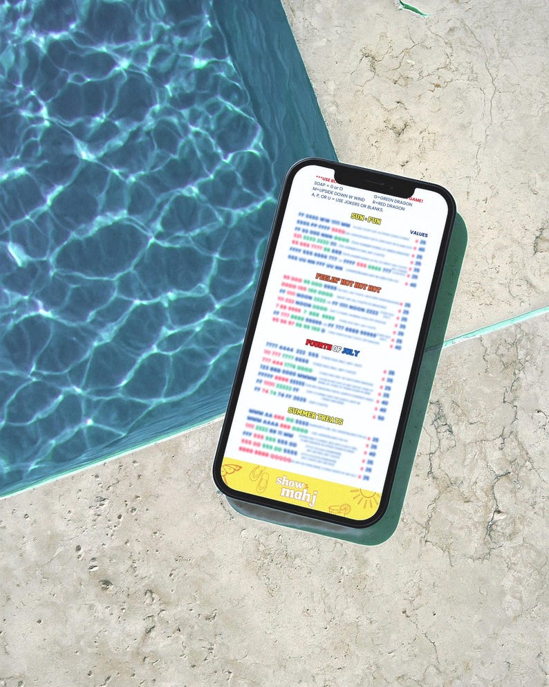 Puede incluir: Un smartphone muestra un men&uacute; con texto, incluyendo "50% FUN" y "Fourth of July". El tel&eacute;fono es negro con un logo amarillo que dice "show mahj". El tel&eacute;fono est&aacute; sobre una superficie de piedra clara junto a una piscina.