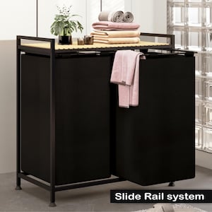 May include: Black metal laundry hamper with two pull-out drawers and a slide rail system. The hamper has a wooden top shelf and is shown with folded towels on top.