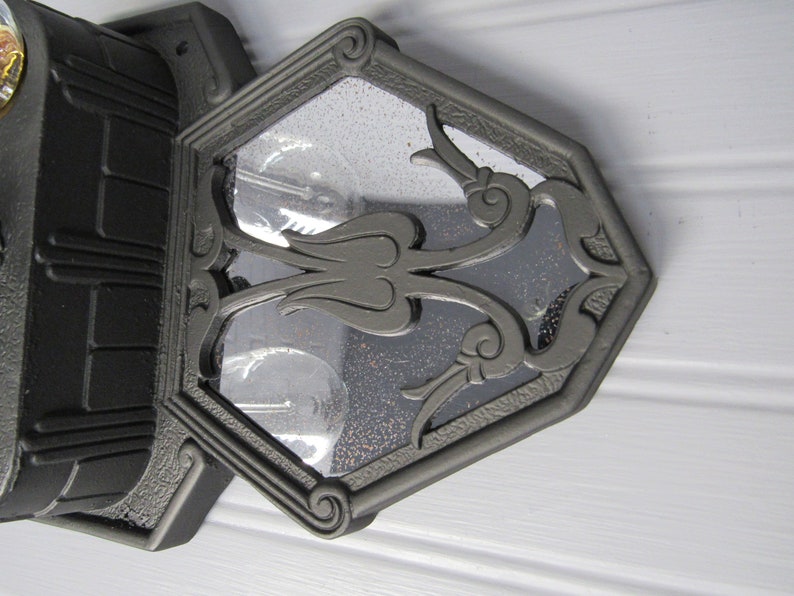 May include: Black cast iron stove with a decorative glass door featuring a floral design. The door is open and the interior of the stove is visible.