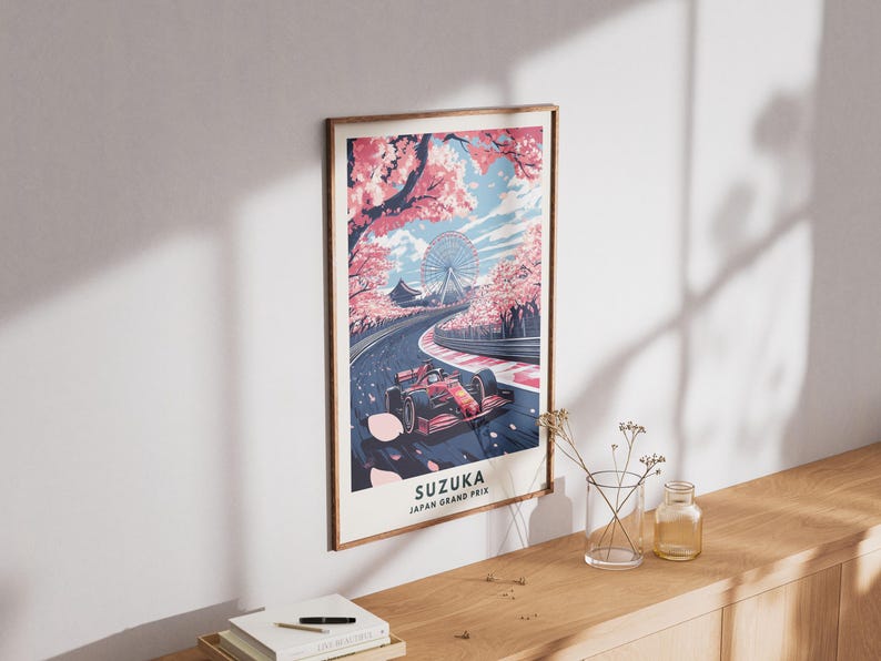 May include: A framed poster featuring a Formula 1 race car speeding on a track, with cherry blossoms and a Ferris wheel in the background. The poster reads "SUZUKA JAPAN GRAND PRIX".