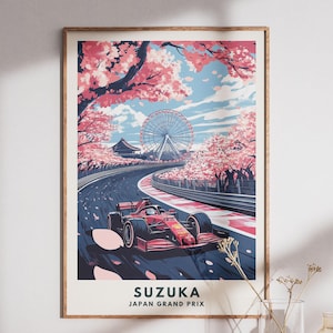 May include: A framed art print of the Suzuka Japan Grand Prix. The artwork depicts a red race car on a track lined with cherry blossom trees. A Ferris wheel and traditional Japanese architecture are in the background. The sky is blue with clouds.