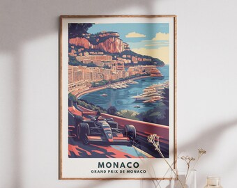 Può includere: Una stampa artistica incorniciata del Gran Premio di Monaco. L'immagine presenta un'auto da corsa su una pista con la città e la costa sullo sfondo. La stampa ha uno stile vintage da manifesto di viaggio con le parole "MONACO GRAND PRIX DE MONACO" in basso.