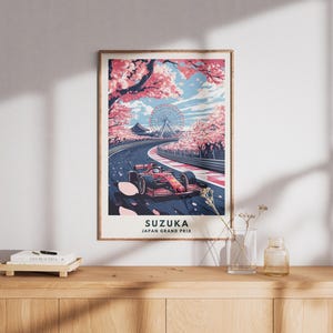 May include: A framed art print featuring a Formula 1 race car on a track, with cherry blossom trees and a Ferris wheel in the background. The print is labeled "SUZUKA JAPAN GRAND PRIX". The color palette includes red, pink, blue, and white.