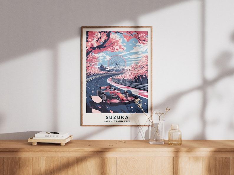 May include: A framed art print featuring a Formula 1 race car on a track, with cherry blossom trees and a Ferris wheel in the background. The print is labeled "SUZUKA JAPAN GRAND PRIX". The color palette includes red, pink, blue, and white.