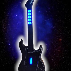 May include: A black electric guitar with blue LED lights on the fretboard and body. The guitar is a Kramer brand.
