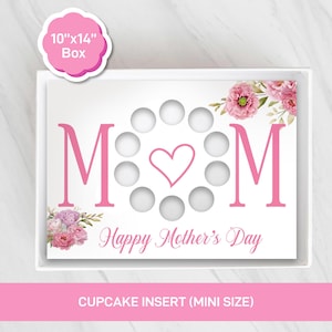 Puede incluir: Insert de cupcake blanco con texto rosa "MOM" con un corazón y "Happy Mother's Day" debajo. El inserto tiene recortes circulares para cupcakes y detalles florales rosas. La caja mide aproximadamente 25.4cm x 35.6cm.