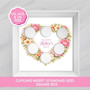 May include: A white square cupcake insert featuring a heart-shaped arrangement of pink and peach flowers with green leaves. The centre contains the text Happy Mother's Day. There are five circular cutouts for cupcakes within the floral heart design.