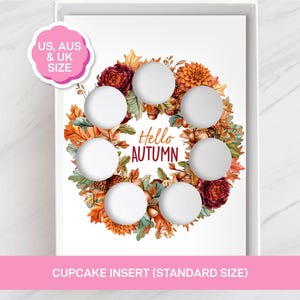 Puede incluir: Un inserto para cupcakes blanco con una corona circular de hojas de otoño, bellotas y flores en tonos naranja, rojo y marrón. El texto central dice Hello Autumn en letra cursiva y de imprenta. Incluye seis recortes circulares para cupcakes.