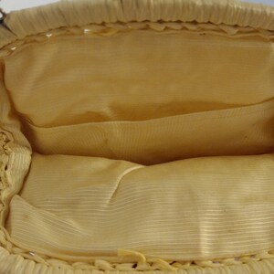 May include: A yellow beaded purse with a woven design and a fabric lining. The purse has a metal clasp and a chain strap.