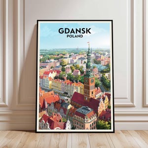 Könnte beinhalten: Ein gerahmter Druck mit einer lebendigen Illustration von Danzig, Polen. Das Kunstwerk zeigt eine detaillierte Stadtlandschaft mit roten Ziegeldächern, farbenfrohen Gebäuden und einem markanten Glockenturm. Der Himmel ist hellblau, mit dem Text "GDANSK POLAND".