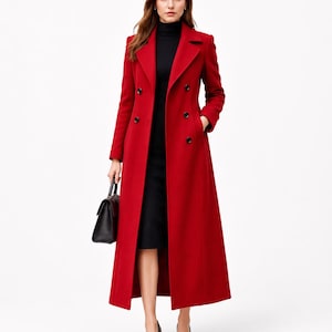 May include: A long, vibrant red double-breasted wool coat featuring notched lapels, long sleeves, and black buttons. The coat is worn over a black turtleneck dress and is paired with a black handbag and black pointed-toe high-heeled shoes.