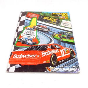 Può includere: Una copertina di programma di corse vintage con un'auto da corsa Budweiser rossa con il numero 11. La copertina include immagini di altre auto da corsa su una pista, con il testo "New Hampshire International Speedway" e "July 9-11, 1993."