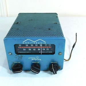 May include: Vintage blue Regency Monitoradio with a perforated metal top. The radio features a frequency dial, tuning, squelch, and volume knobs. The text "MONITORADIO" and "Regency" are visible on the face of the radio.