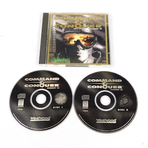 May include: A Command & Conquer Windows '95 PC game. The game case and two discs are visible. The game case features a soldier wearing goggles. The discs are black with white text and the Westwood Studios logo.