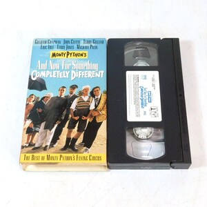 May include: A VHS tape and its cover for the film "And Now For Something Completely Different" by Monty Python. The cover is light blue with a group of men in suits and the text "The Best of Monty Python's Flying Circus".