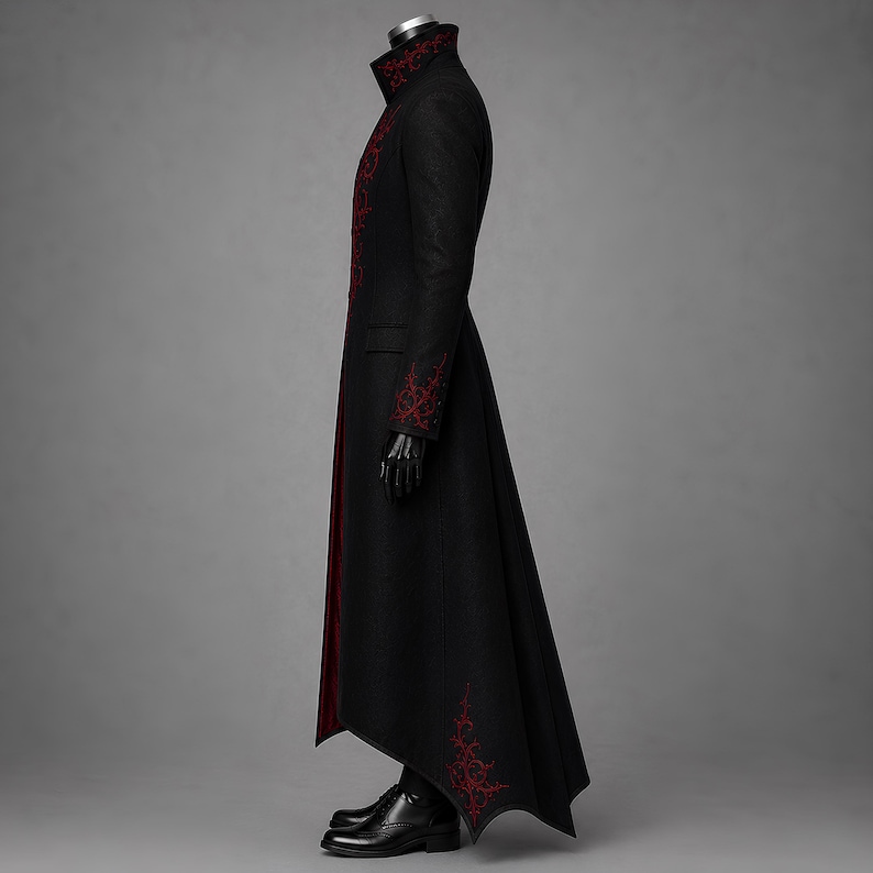 Side profile of a black Victorian Gothic tailcoat for men, designed with deep crimson accents, embroidered cuffs, a sharply raised collar and an elegant floor-length silhouette. The dramatic vampire longcoat creates a bold choice for Dracula costumes, Halloween celebrations, Renaissance festivals and alternative formal occasions.