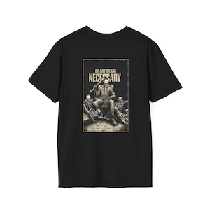 May include: Black t-shirt featuring a graphic with the text "BY ANY MEANS NECESSARY". The graphic depicts a seated figure holding a baseball bat, surrounded by skeletal figures. The design is in shades of beige and brown.