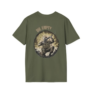 May include: Olive green t-shirt featuring a graphic of a soldier kneeling with a rifle, set within a circular design. The words "DIE EMPTY" are printed above the graphic in a tan color. The shirt is made of a soft material.