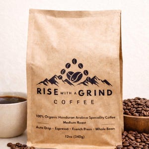 May include: A white ceramic mug with a black handle and the text "But First, Coffee" in a black, bold font. The mug is on a white surface.