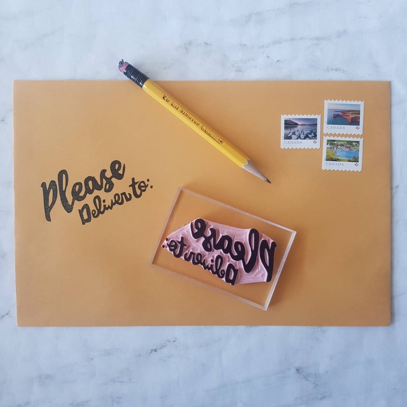 May include: A brown envelope with the text "Please deliver to:" written in black ink. A pink rubber stamp with the text "Please deliver to:" is on top of the envelope. There are three Canadian stamps on the upper right corner of the envelope.