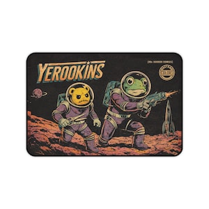 May include: Mousepad featuring a retro comic book illustration. The image depicts two figures in space suits, one a bear and the other a frog, on a red planet. The text "YEROOKINS" is at the top, with "[90s HORROR COMICS]" and "RETRO COLORS" in the corner.