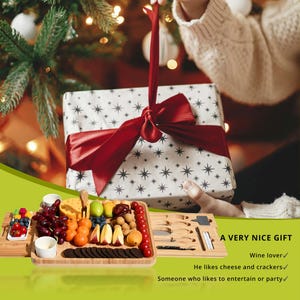 May include: A gift set featuring a wooden charcuterie board with various fruits, cheeses, and crackers. Includes a set of knives and a gift box wrapped in white paper with a red bow. The text reads "A VERY NICE GIFT".
