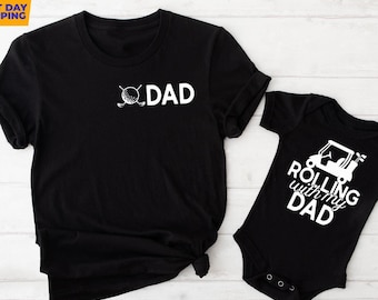 May include: Black t-shirt with the text "DAD" and a golf ball and clubs graphic. A black baby onesie with the text "Rolling with my DAD" and a golf cart graphic.