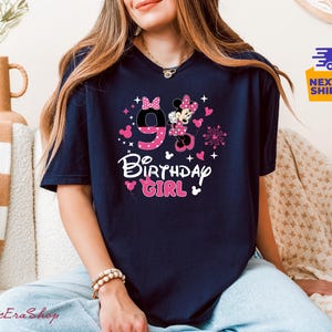 K&ouml;nnte beinhalten: Marineblaues T-Shirt mit einem Minnie-Maus-Design f&uuml;r den 9. Geburtstag. Die Grafik zeigt die Zahl 9, Minnie Maus, Herzen und die Worte "Birthday Girl" in Wei&szlig; und Rosa. Das Shirt ist ein l&auml;ssiger Stil.