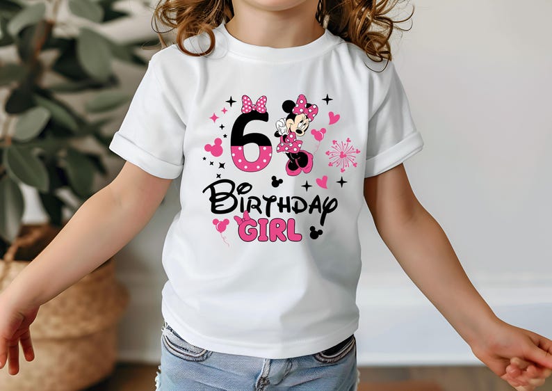 K&ouml;nnte beinhalten: Wei&szlig;es T-Shirt mit Minnie Mouse-Motiv, der Zahl 6, Herzen und dem Text "Birthday Girl" in Schwarz und Pink. Das T-Shirt hat hochgekrempelte &Auml;rmel und ist f&uuml;r ein Kind konzipiert.