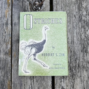 May include: A hardback book titled Ostriches by Herbert S. Zim, illustrated by Russell Francis Peterson. The cover is light green with a white speckled texture and features a black and white line drawing of an ostrich in the centre.