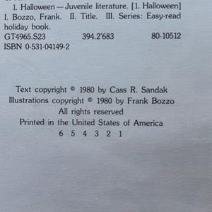 May include: A white book copyright page with black text. It lists 1. Halloween - Juvenile literature. I. Bozzo, Frank. II. Title. III. Series: Easy-read holiday book. GT4965.S23 394.2'683 80-10512 ISBN 0-531-04149-2. Text copyright 1980 by Cass R. Sandak.