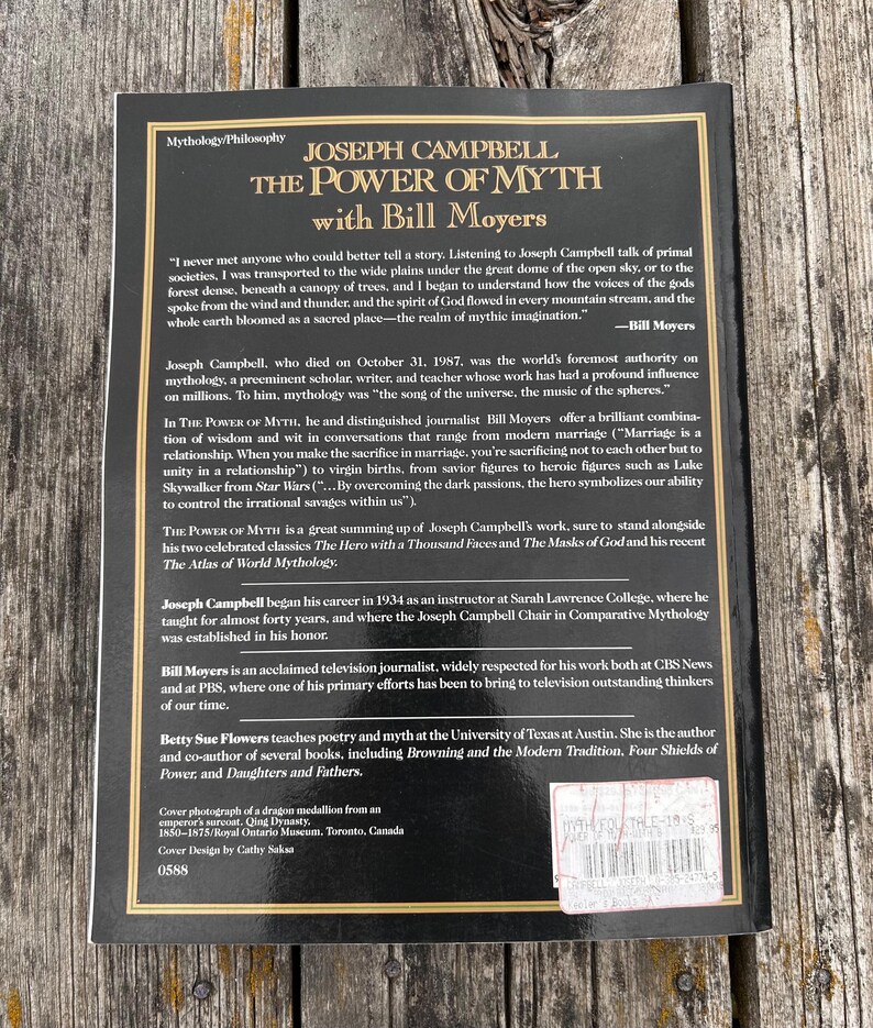 K&ouml;nnte beinhalten: Die R&uuml;ckseite des Buches The Power of Myth von Joseph Campbell mit Bill Moyers. Es hat einen schwarzen Hintergrund mit goldenen Rahmenlinien, wei&szlig;en Text &uuml;ber den Buchinhalt, Autorenbiografien und einen Preisaufkleber in der Ecke.