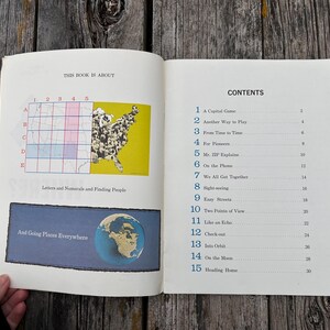 May include: An open book displaying a table of contents on the right page and a map graphic with the text 'THIS BOOK IS ABOUT' and 'Letters and Numerals and Finding People' on the left. The right page lists fifteen chapters with blue numbers.