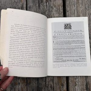 Może przedstawiać: Otwarta książka z białymi stronami i czarnym drukowanym tekstem. Lewa strona zawiera akapity dotyczące wydarzeń historycznych, a prawa strona przedstawia dokument historyczny zatytułowany A PROCLAMATION.
