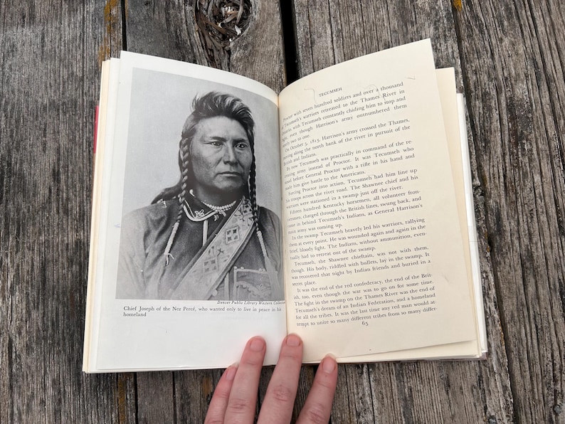 Puede incluir: Un libro abierto con un retrato en blanco y negro del Jefe Joseph de los Nez Perce en la p&aacute;gina izquierda y texto impreso en la derecha. El texto incluye el t&iacute;tulo Tecumseh y detalles sobre eventos hist&oacute;ricos y batallas.