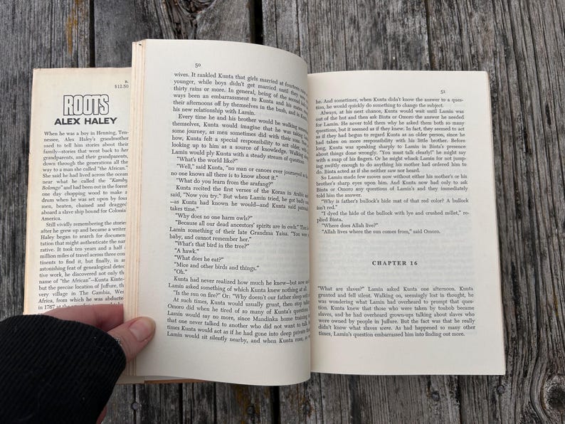 K&ouml;nnte beinhalten: Ein aufgeschlagenes Taschenbuch mit dem Titel Roots von Alex Haley, das gedruckten Text auf cremefarbenen Seiten zeigt. Die linke Seite enth&auml;lt ein Vorwort, w&auml;hrend die rechte Seite den Beginn von Kapitel 16 zeigt. Das Buch ist aufgeschlagen.