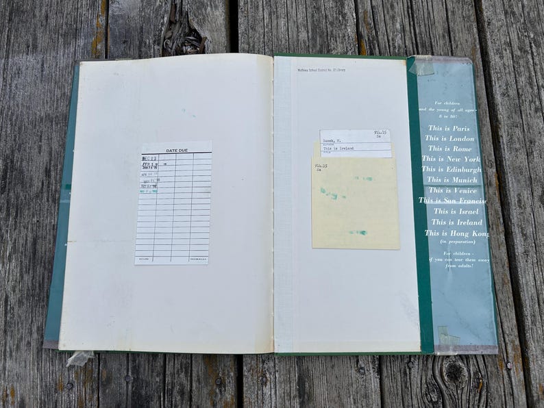 Peut inclure: Un livre de biblioth&egrave;que vintage ouvert avec une fiche de pr&ecirc;t blanche sur la page de gauche et une pochette jaune avec une carte sur la page de droite. La couverture int&eacute;rieure vert fonc&eacute; liste des villes comme Paris, Londres et Rome en blanc.