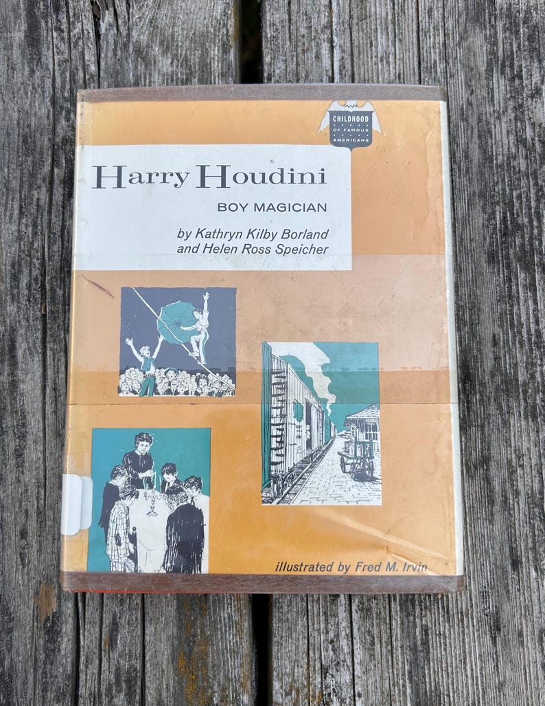 May include: A hardcover book titled Harry Houdini Boy Magician by Kathryn Kilby Borland and Helen Ross Speicher. The tan and white cover features three illustrations depicting a tightrope walker, a group of children, and a train car scene.