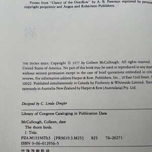May include: A white book copyright page featuring black text. The text includes the title The Thorn Birds, copyright 1977 by Colleen McCullough, and Library of Congress Cataloging in Publication Data. The ISBN 0-06-012956-5 is printed at the bottom.