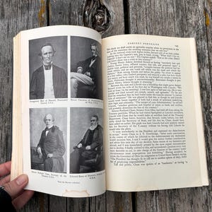 May include: An open book featuring black and white historical portraits of four men on the left page, with printed text captions below each image. The right page contains columns of printed text under the heading Cabinet Portraits.