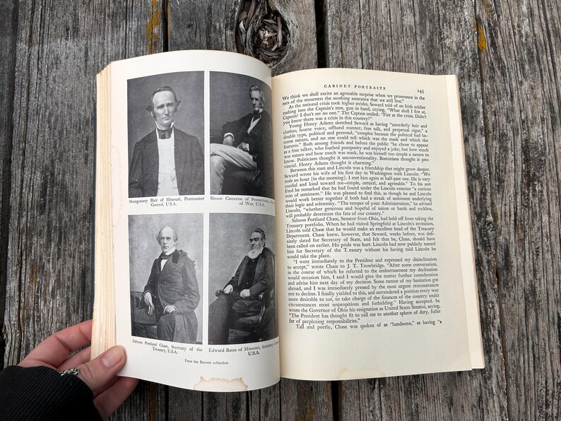 May include: An open book featuring black and white historical portraits of four men on the left page, with printed text captions below each image. The right page contains columns of printed text under the heading Cabinet Portraits.