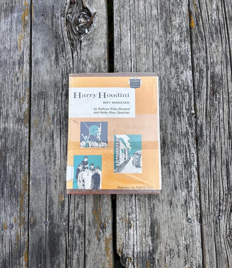 May include: A hardcover book titled Harry Houdini Boy Magician by Kathryn Kilby Borland and Helen Ross Speicher, illustrated by Fred M. Irvin. The cover features a tan background with two black and white illustrations depicting a magician and a train.