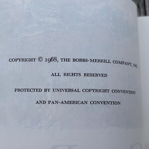 May include: A white book page with black printed text that reads: COPYRIGHT &copy; 1968, THE BOBBS-MERRILL COMPANY, INC. ALL RIGHTS RESERVED. PROTECTED BY UNIVERSAL COPYRIGHT CONVENTION AND PAN-AMERICAN CONVENTION. The paper has a faint, light grey illustration.
