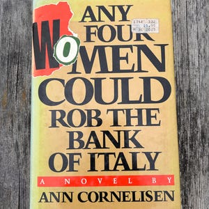 May include: A hardcover book with a yellow cover featuring the title Any Four Women Could Rob the Bank of Italy by Ann Cornelisen in bold black lettering. A red and green sticker partially covers the word Women on the front cover.