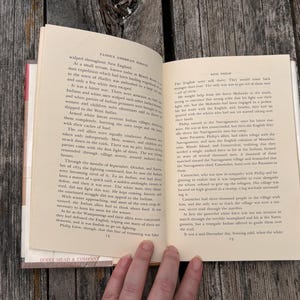 Puede incluir: Un libro de tapa dura abierto con p&aacute;ginas de color crema y texto impreso en negro. La p&aacute;gina izquierda est&aacute; numerada con el 14 y la derecha con el 15. El texto incluye los encabezados Famous American Indians y King Philip.