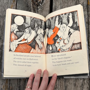 Może przedstawiać: Otwarta książka na stronach 30 i 31 z czarno-pomarańczowymi ilustracjami przedstawiającymi czarownice tańczące i grające na dudach. Tekst brzmi: In Scotland people once believed all witches met on Halloween. The devil called them together. They danced all night. Music was played on the devil's bagpipe. This bagpipe was made from hens' heads and cats' tails!