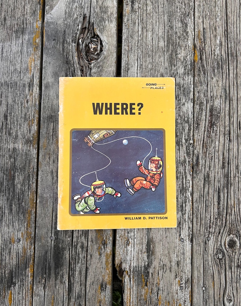 May include: A yellow softcover book titled WHERE? by William D. Pattison, featuring a Going Places logo and a central illustration of two astronauts in space suits floating in the dark cosmos near a spacecraft and a small white planet.