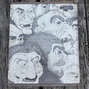 May include: A rectangular book cover featuring a black and white ink illustration of multiple grotesque, troll-like faces with exaggerated features, sharp teeth, and textured skin. The ISBN 0-397-31621-6 is printed in small text at the bottom.