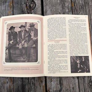 K&ouml;nnte beinhalten: Ein aufgeschlagenes Buch mit Schwarz-Wei&szlig;-Fotos von Schauspielern in Westernkleidung und gedrucktem biografischem Text &uuml;ber George Roy Hill und Paul Monash. Die Seiten enthalten Textspalten und zwei gerahmte Fotoillustrationen.