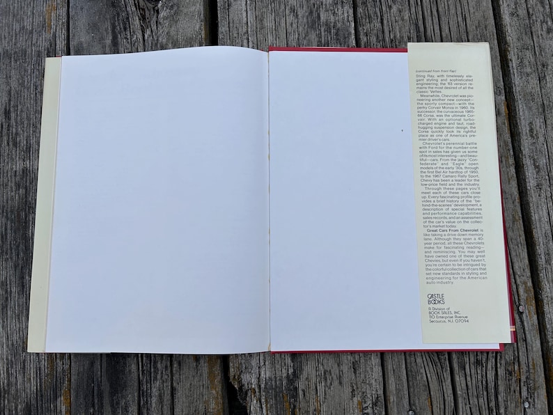 Op de afbeelding: Een open hardcover boek met lege witte pagina's en een beige stofomslagflap aan de rechterkant. De flap bevat gedrukte tekst over Chevrolet-auto's en de uitgever Castle Books, een divisie van Book Sales, Inc., Secaucus, NJ 07094.